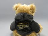 a teddy bear that is wearing a black jacket