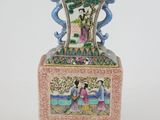 a vase with a painting on it sitting on a table