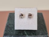 a pair of earrings sitting on top of a marble block