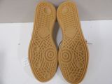 pair of brown shoes on a white surface with a white box in the background