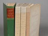 three books are stacked on top of each other on a gray surface
