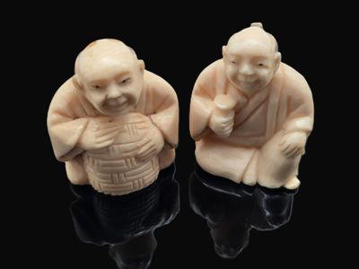 paire de figurines en ivoire sculpté représentant un homme et une femme