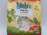 un sac de graines pour oiseaux posé sur une table blanche