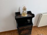 une petite table sur laquelle se trouve un vase, dans un coin de la pièce