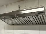 a kitchen with a stove, refrigerator, and a range hood