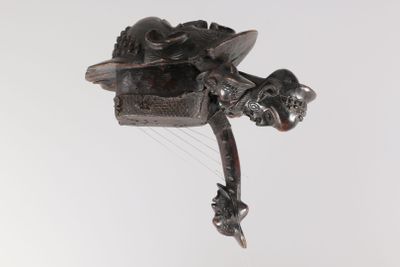 une sculpture métallique représentant un oiseau en plein vol sur fond blanc