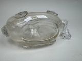 a glass bowl with a frog on it on a table