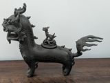 a small statue of a horse with a cat on its back