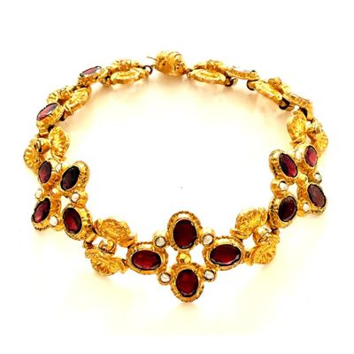 un gros plan d'un bracelet en or orné de grenats