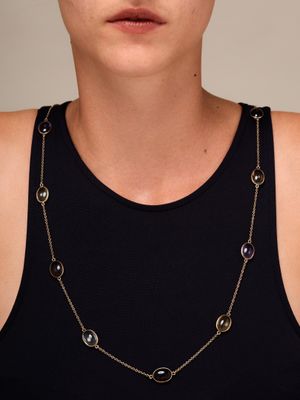 une femme portant un débardeur noir et un collier à chaîne dorée