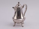 an antique silver coffee pot on a stand on a white background