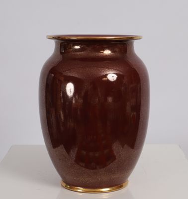 a brown vase sitting on a table with a white background