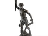 une statue antique en bronze représentant un homme tenant une épée, sur fond blanc