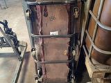 une vieille valise posée à côté d'un porte-vêtements en métal dans une pièce