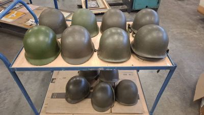 many helmets sitting on a shelf in a warehouse