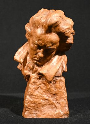 sculpture représentant le buste d'un homme coiffé d'un chapeau, sur fond noir