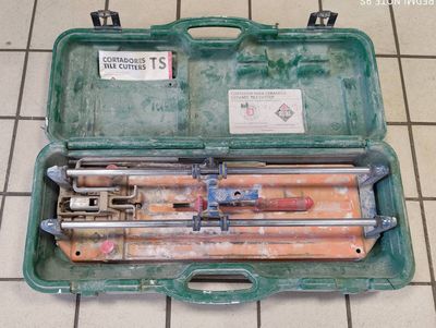 a green case with tools inside of it on a tiled floor