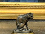 une statue représentant un chien assis sur un socle devant un miroir