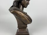 a bronze bust of a woman with long hair