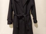Le manteau est noir et est muni d'une ceinture