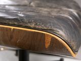 a close up of a black leather seat on a wooden chair