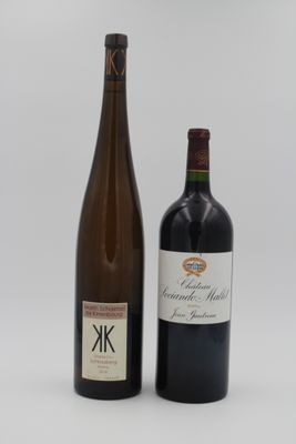 deux bouteilles de vin posées l'une à côté de l'autre sur une surface blanche
