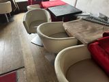 Plusieurs chaises et tables sont alignées en rang dans un restaurant