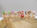 seven little figurines of different sizes on a wooden board