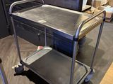a metal cart that is on the floor in a room