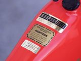 a close up of a red motorcycle parked in a parking lot