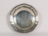 un plateau en argent posé sur une table blanche, avec un miroir
