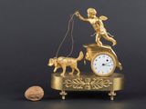 une figurine en or représentant une horloge et un chien en laisse