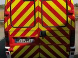 a red and yellow van parked on the side of the road