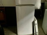a white refrigerator sitting in the corner of a kitchen