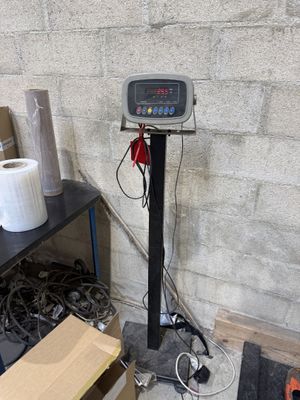 une image représentant une balance dans une pièce où se trouvent de nombreuses boîtes