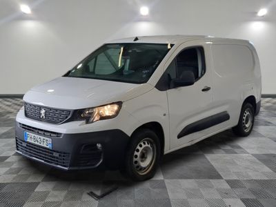 la camionnette blanche est garée dans une grande pièce au sol en damier