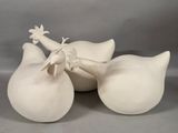 three white vases sitting on a table with one of them holding a bird