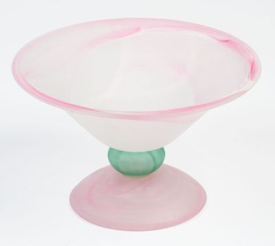 a pink glass bowl with a green base on a white surface