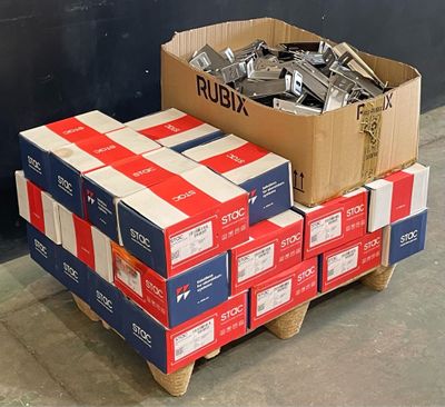 une pile de cartons posée sur une palette contre un mur