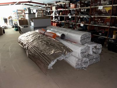 de nombreux rouleaux de papier d'aluminium par terre dans un entrepôt
