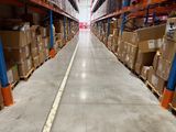 a long line of boxes on the floor in a large warehouse