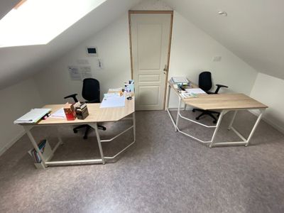 deux bureaux dans un coin d'une pièce dotée d'une verrière