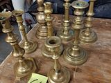 a lot of brass candles on a table with a price tag