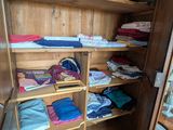 une armoire sur laquelle sont posés de nombreux vêtements pliés