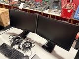 two computer monitors and a keyboard on a desk