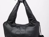 a black leather bag with a bow on the handle