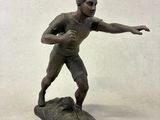 une figurine en bronze représentant un homme sur une planche de surf