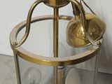 une lanterne en verre et en laiton surmontée d'une ampoule