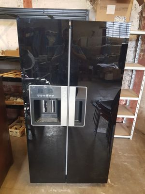 un grand réfrigérateur noir à deux portes avec un compartiment congélateur