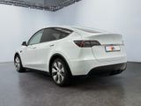 the rear end of a white tesla suv parked in a garage